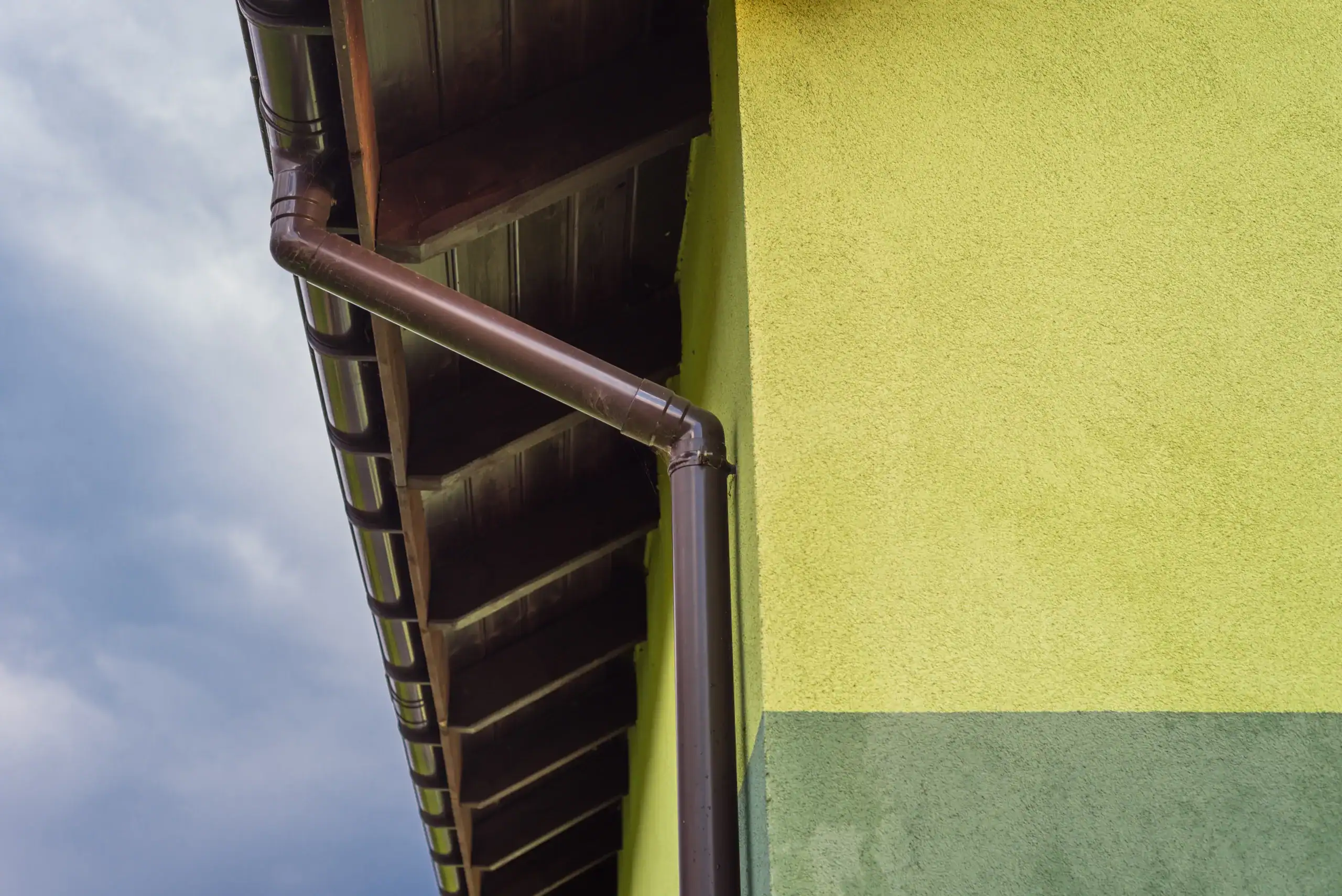 light-green-business-facade-with-visible-roof-soffit and custom commercial colored gutter