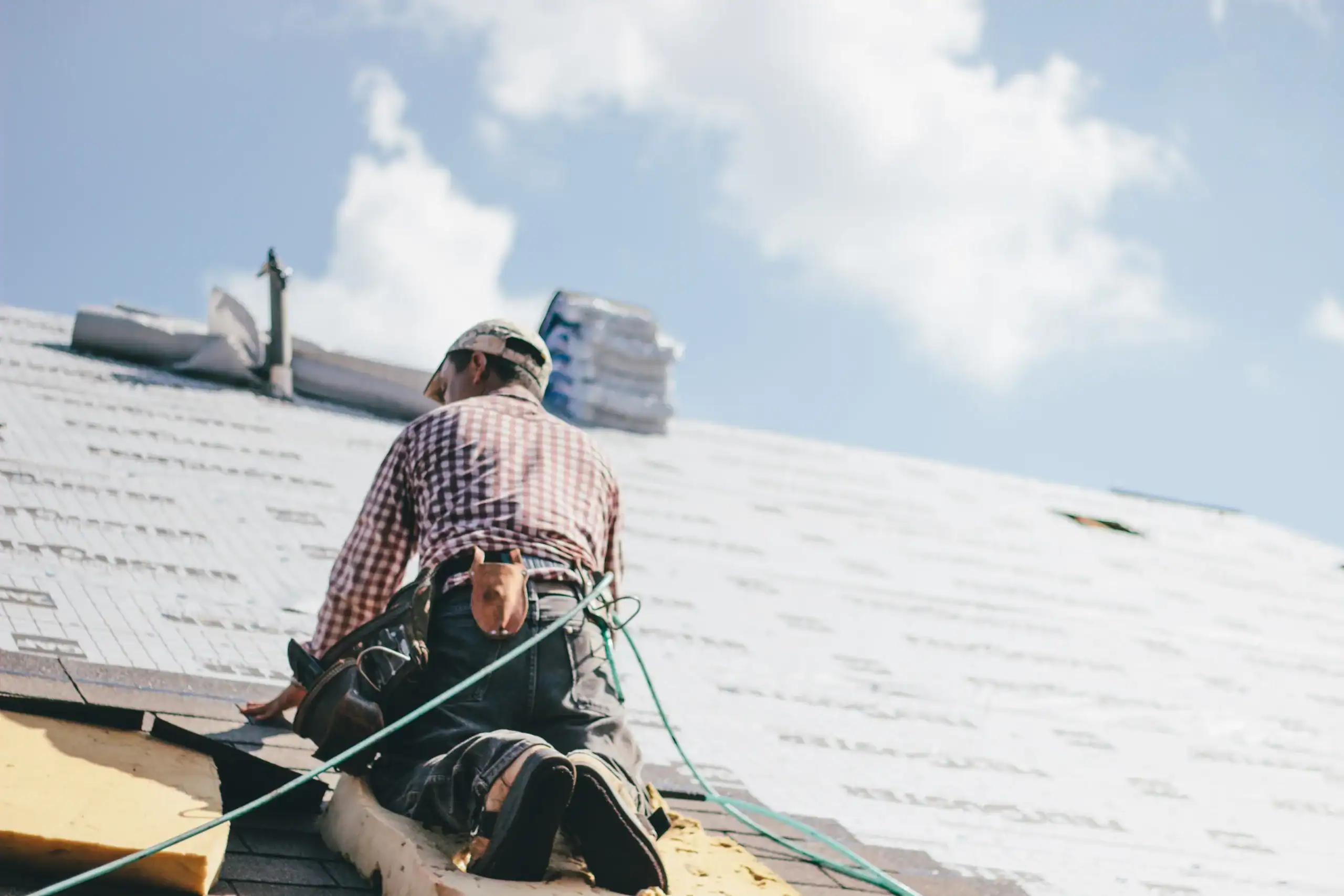 Roofer installing shingles on a home roof