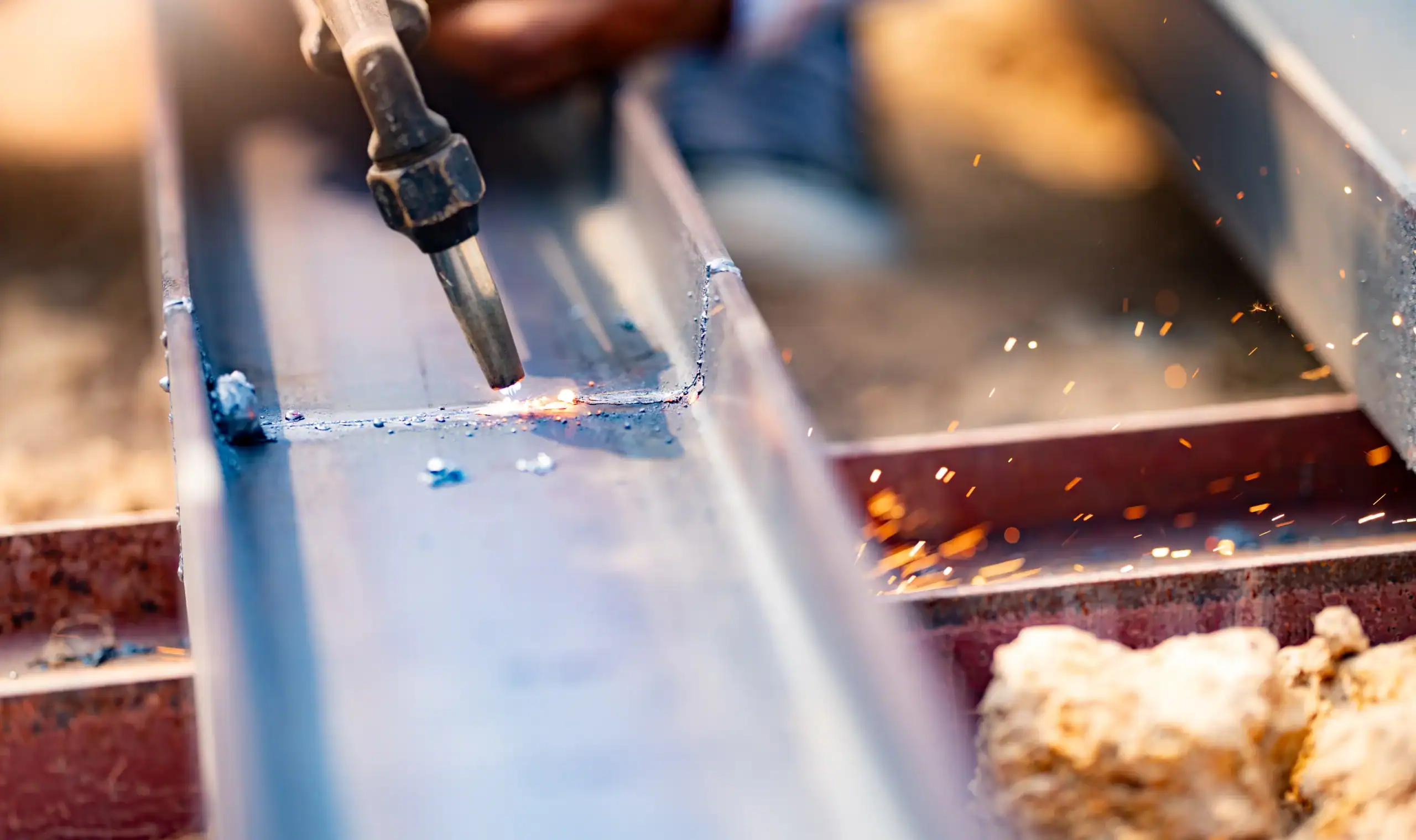 Skilled labor and craftsmanship in metal fabrication. Use of torches for cutting metal. Safety measures and personal protective equipment for metalworkers. Precision and accuracy in metal cutting.