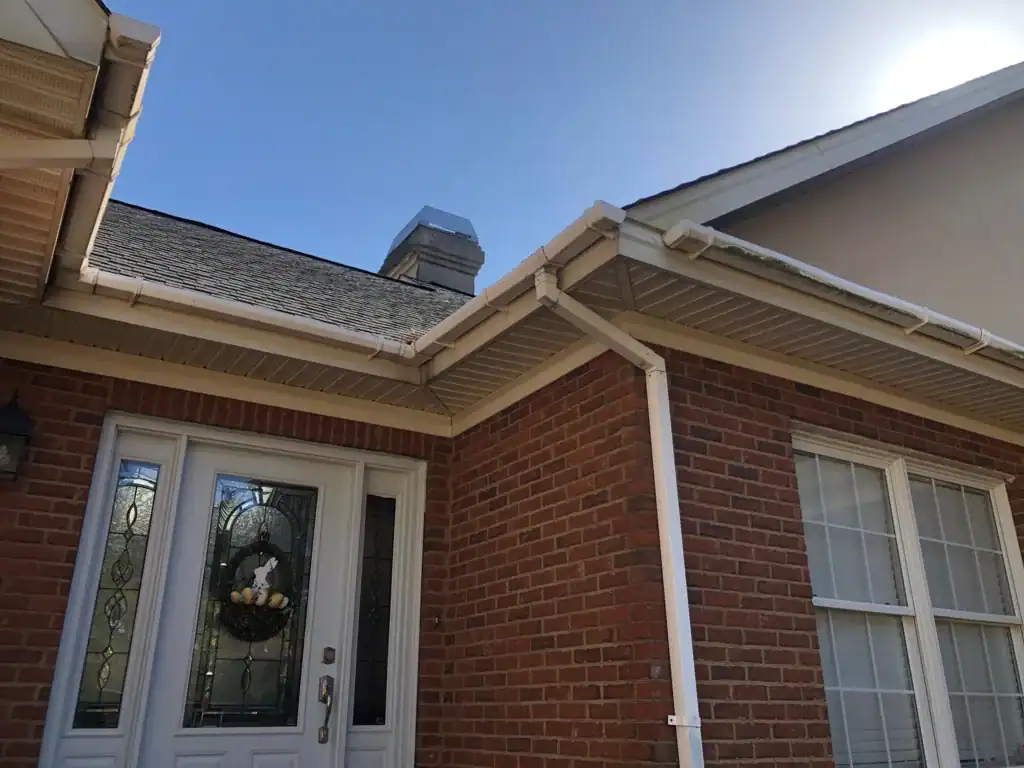 Exterior home brick wall with roof edge and gutter system.