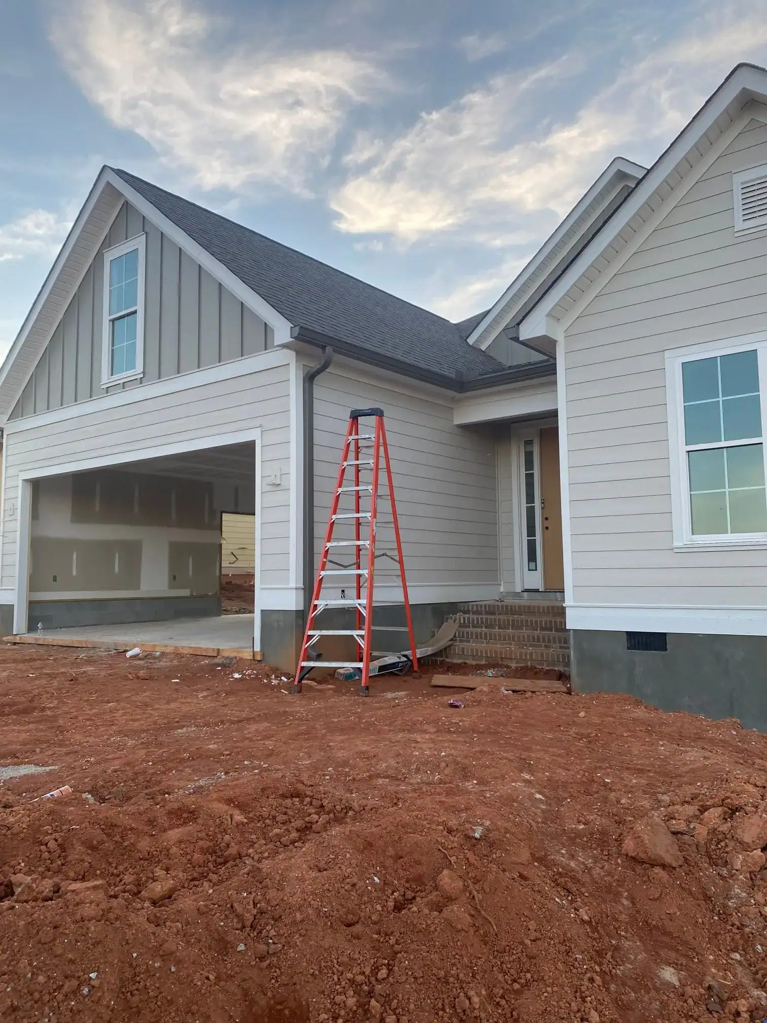New home exterior with siding and garage in progress.