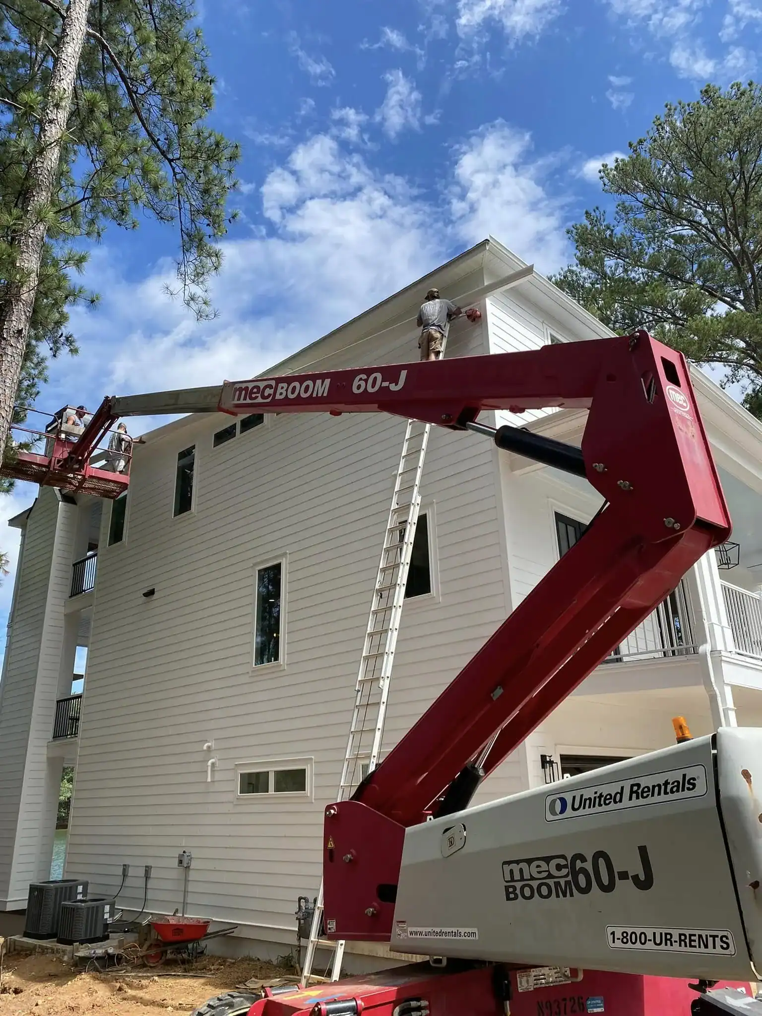 Exterior house painting with professional equipment.