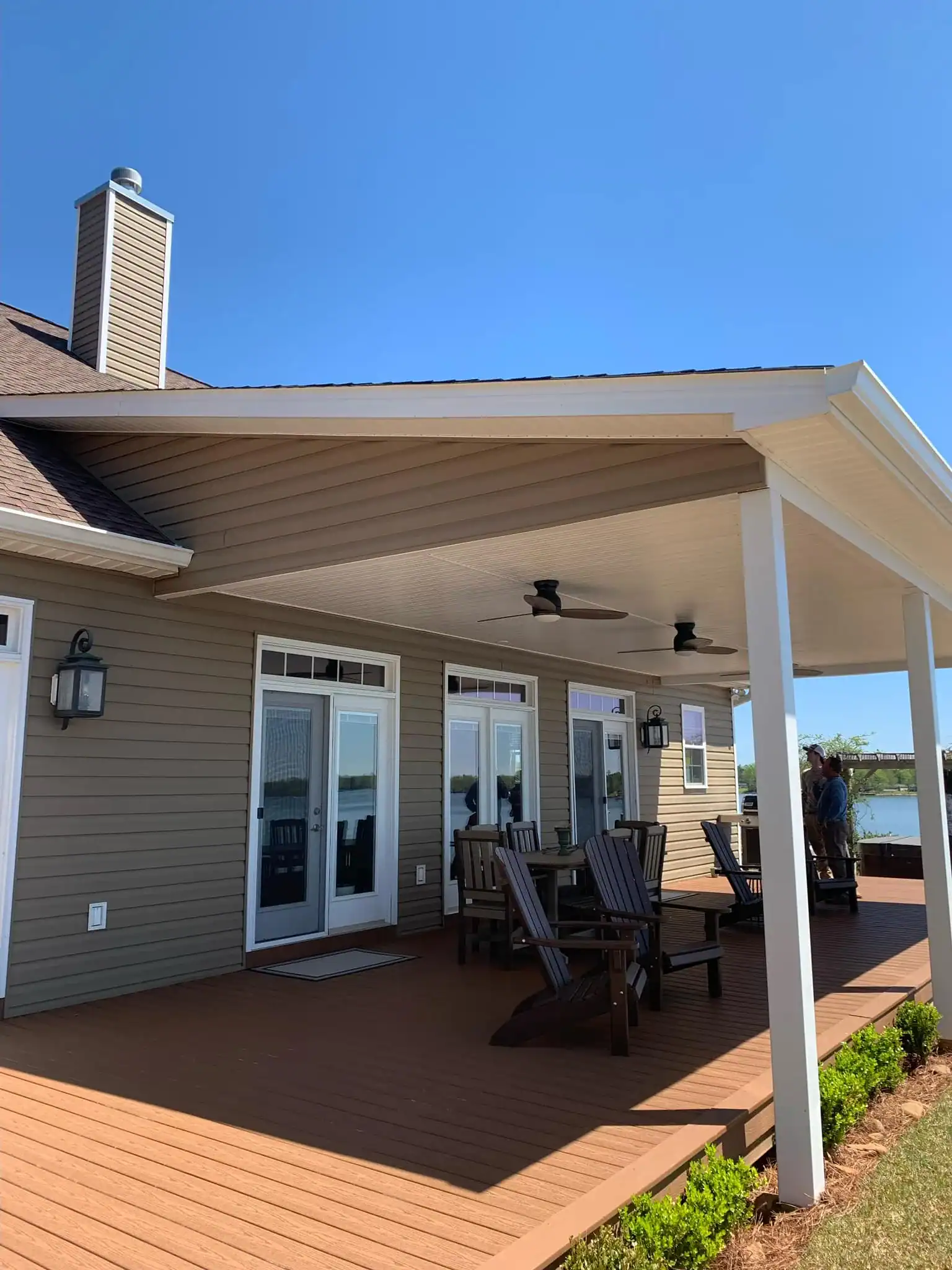 Outdoor patio with covered deck, ceiling fans, and seating for relaxation.