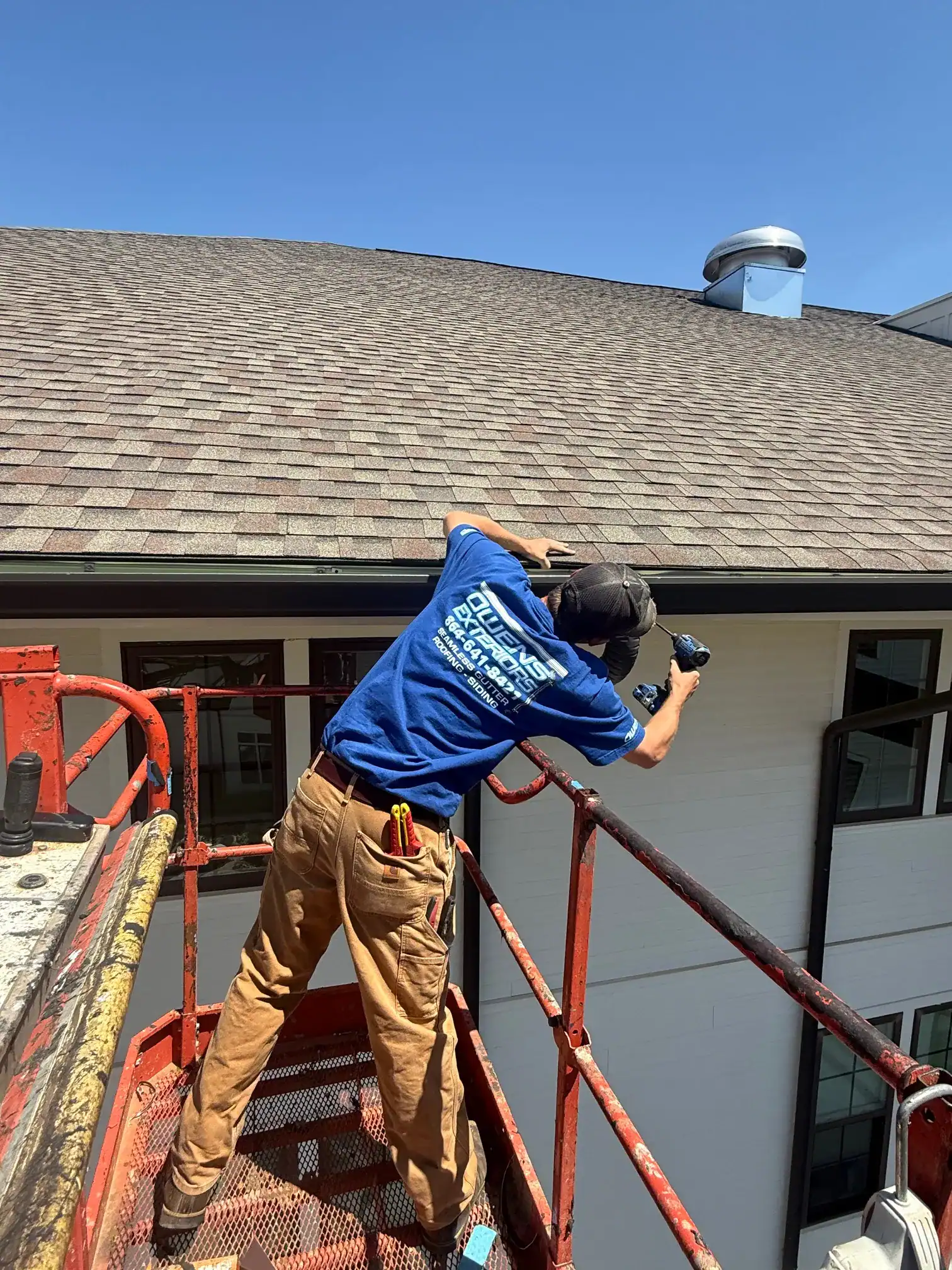 Roof inspection by professional exterior service technician on residential building.